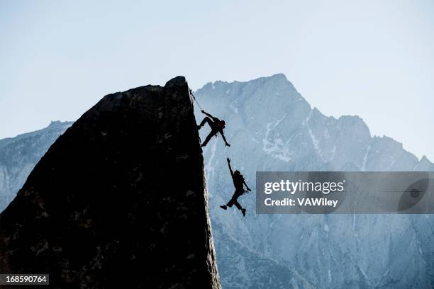 drama - climbing help stock pictures, royalty-free photos & images