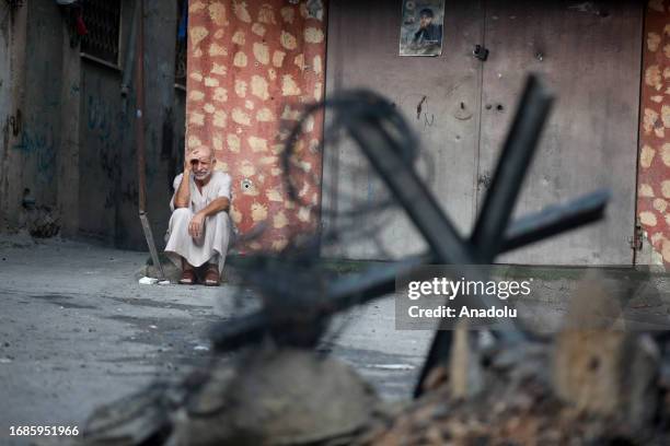 Man sitting on the ground puts his hand to his forehead after Israeli forces raid on the Nur Shams Refugee Camp in Tulkarm, West Bank on September...