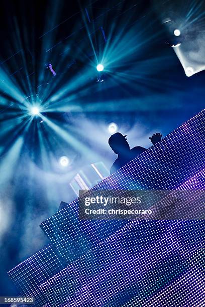 a silhouette of a dj at a club - dj stock pictures, royalty-free photos & images