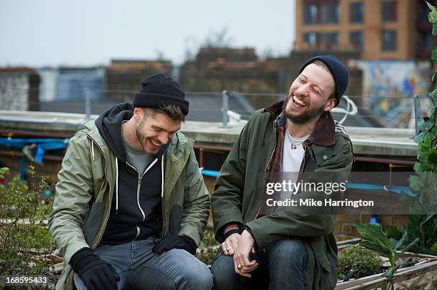 men sitting in urban roof garden laughing. - male friends hanging out ストックフォトと画像