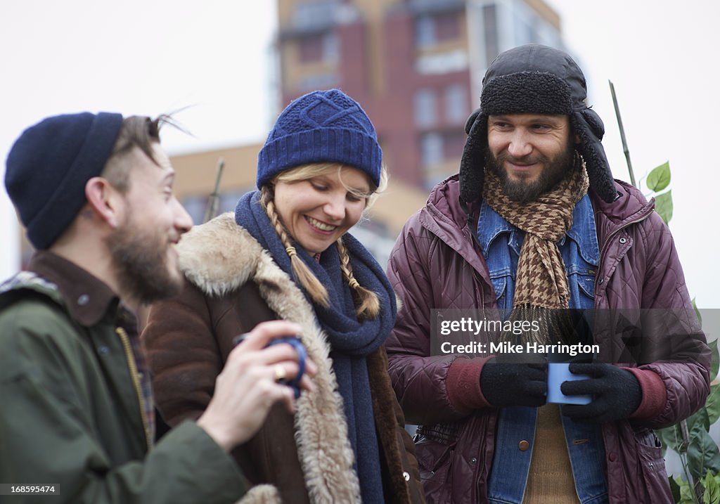 Friends in roof garden conversing and smiling.