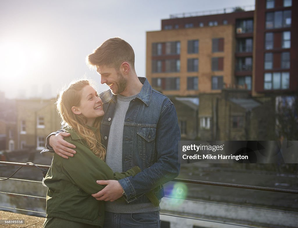 Young couple embracing in urban roof garden.