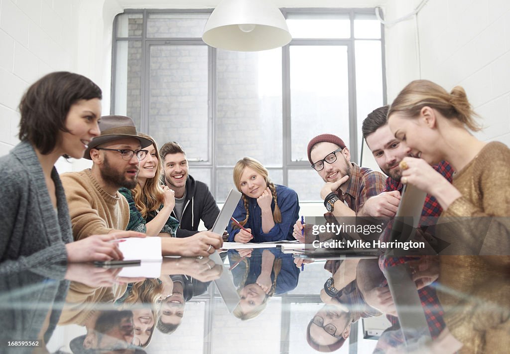 Young woman sharing ideas on ipad in meeting