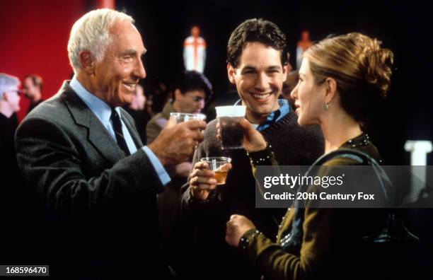 Nigel Hawthorne, Paul Rudd and Jennifer Aniston toast each other in a scene from the film 'The Object Of My Affection', 1998.