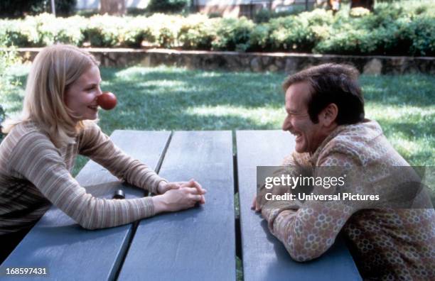 Monica Potter sits with Robin Williams in a scene from the film 'Patch Adams', 1998.