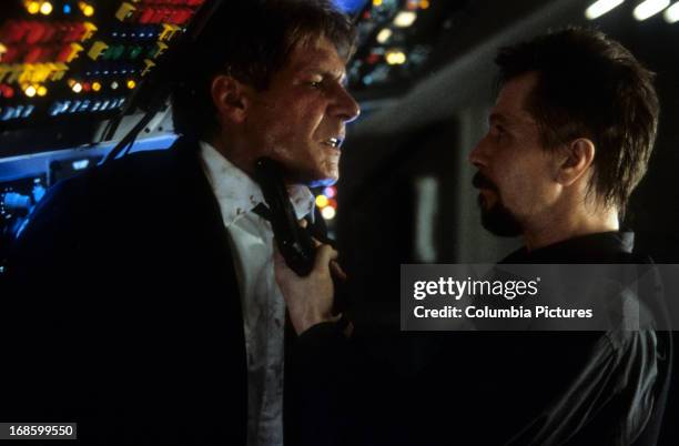 Gary Oldman aiming gun at Harrison Ford in a scene from the film 'Air Force One', 1997.