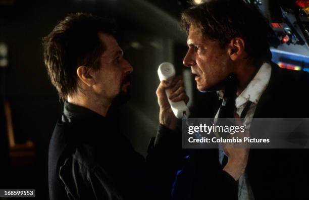 Gary Oldman aiming gun at Harrison Ford in a scene from the film 'Air Force One', 1997.