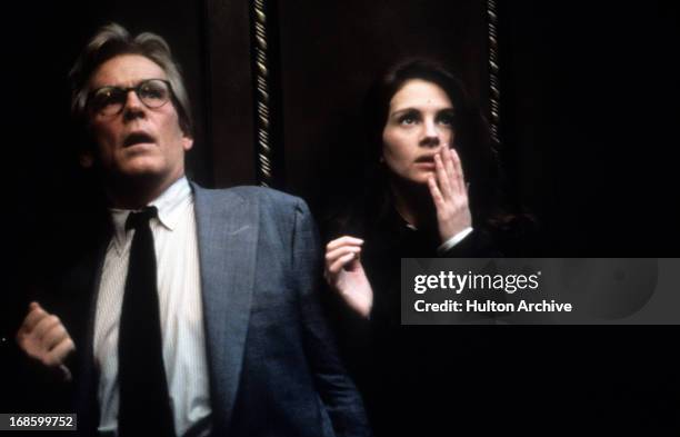 Nick Nolte and Julia Roberts standing next to each other in shock of something they see in front of them in a scene from the film 'I Love Trouble',...