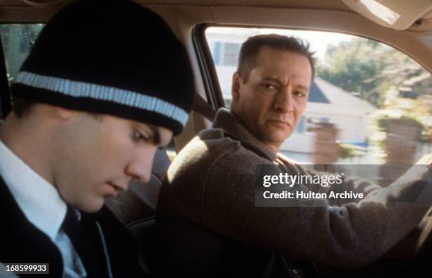 Wes Bentley wearing a sweater cap and sitting in the passenger seat of a car next to Chris Cooper in a scene from the film 'American Beauty', 1999.