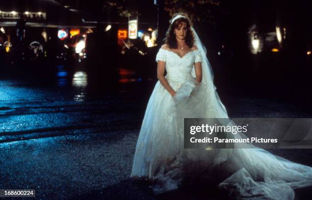 Joan Cusack standing in the street in a wedding gown in a scene from the film 'In & Out', 1997.