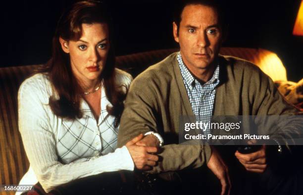 Joan Cusack and Kevin Kline sitting on the sofa together in a scene from the film 'In & Out', 1997.