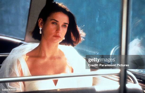 Demi Moore riding public transportation while dressed in formal wear in a scene from the film 'Indecent Proposal', 1993.