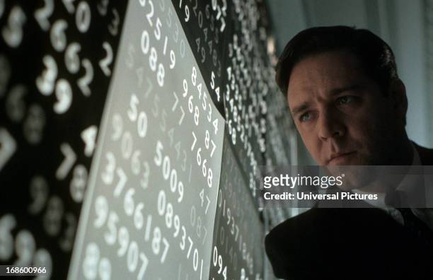 Russell Crowe looking at wall of numbers in a scene from the film 'A Beautiful Mind', 2001.