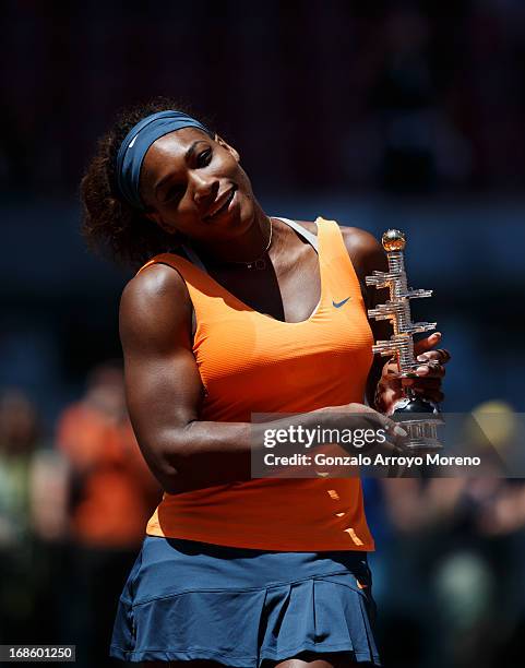 Serena Williams of the US poses with the trophy after winning her final match against Maria Sharapova of Russia on day nine of the Mutua Madrid Open...