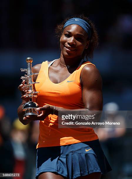 Serena Williams of the US poses with the trophy after winning her final match against Maria Sharapova of Russia on day nine of the Mutua Madrid Open...