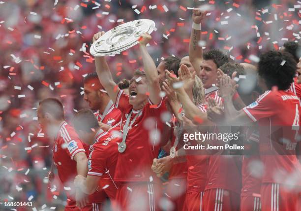 Bastian Schweinsteiger celebrates with FC Bayern Muenchen team mates as they receive the championship trophy after the Bundesliga match between FC...