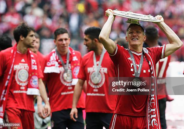 Bastian Schweinsteiger celebrates with FC Bayern Muenchen team mates as they receive the championship trophy after the Bundesliga match between FC...