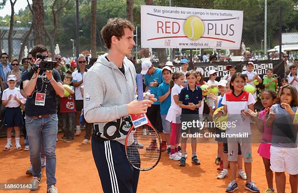 Andy Murray of Great Britain arrive on court to play tennis with a young children during day one of the Internazionali BNL d'Italia 2013 at the Foro...