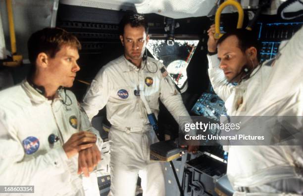 Kevin Bacon, Tom Hanks, and Bill Paxton talking in ship in a scene from the film 'Apollo 13', 1995.