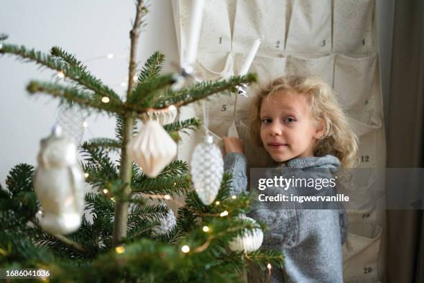 surprised girl opening christmas advent calendar near the christmas tree - child with advent calendar stock pictures, royalty-free photos & images