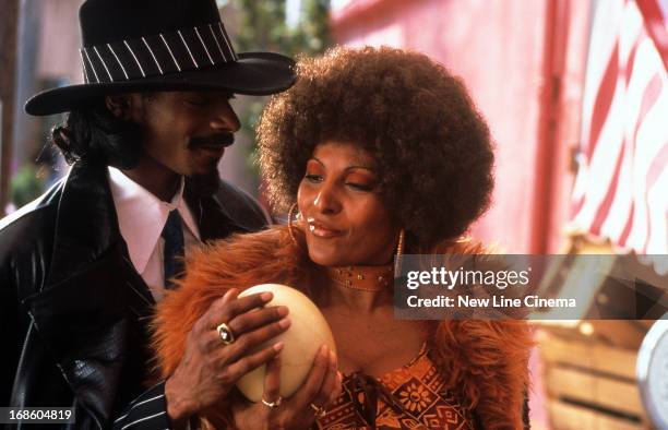 Snoop Dogg and Pam Grier feeling a melon in a scene from the film 'Bones', 2000.