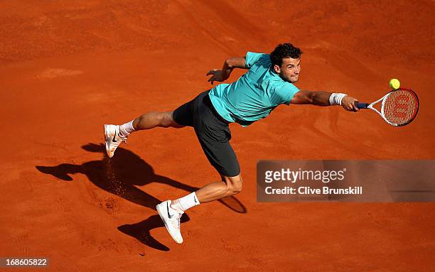 Grigor Dimitrov of Bulgaria leaps into the air to play a backhand against Marcos Baghdatis of Cyprus in their first round match during day one of the...