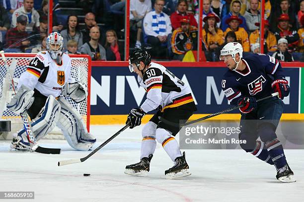 David Moss of USA and Patrick Hager of Germany battle for the puck during the IIHF World Championship group H match between USA and Germany at...