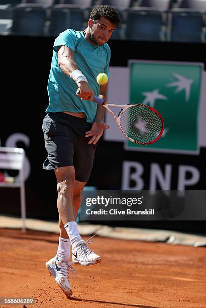 Grigor Dimitrov of Bulgaria leaps into the air to play a backhand against Marcos Baghdatis of Cyprus in their first round match during day one of the...