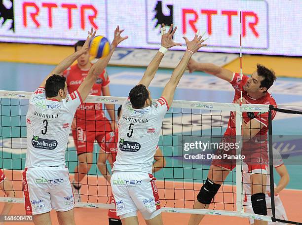 Hristo Zlatanov of Copra Elior Piacenza spikes the ball against to Osmani Juantorena and Emanuele Birarelli of Itas Diatec Trentino during game 5 of...