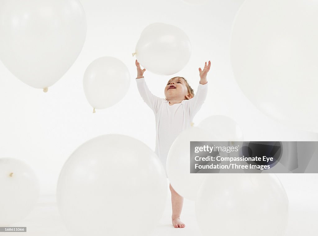 Baby playing with large balloons