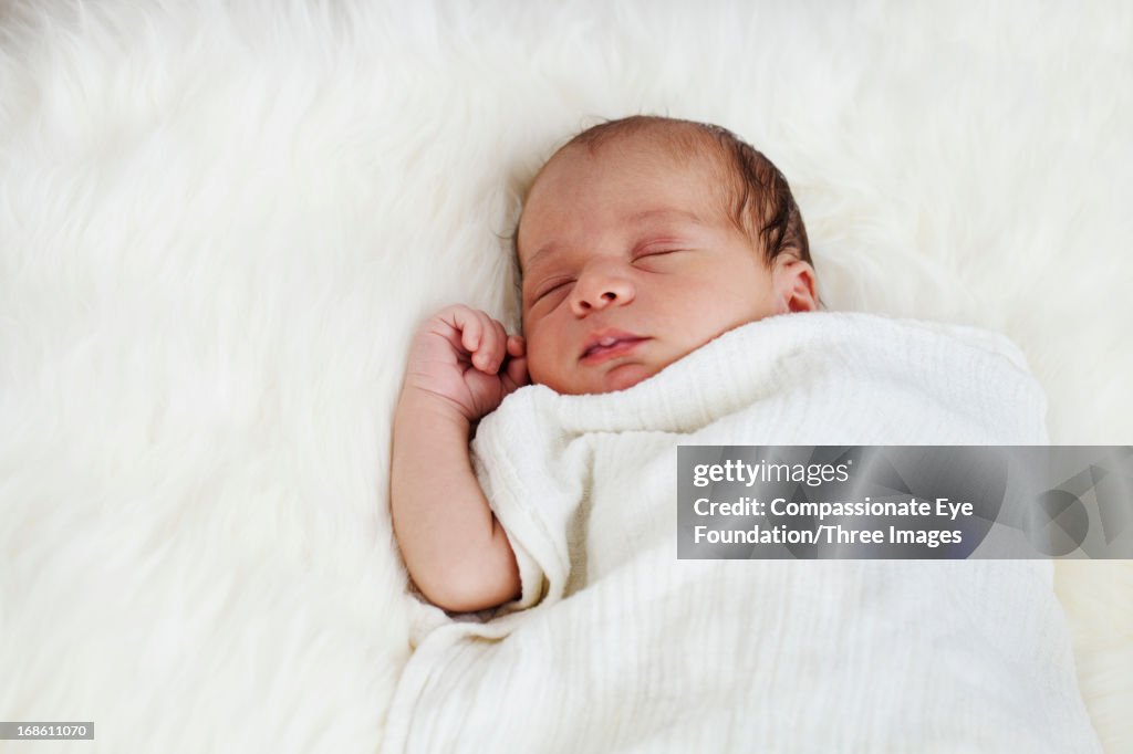 Sleeping baby laying on rug