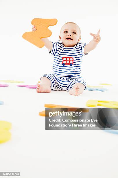 smiling baby playing with toy letters - one baby boy only stock pictures, royalty-free photos & images