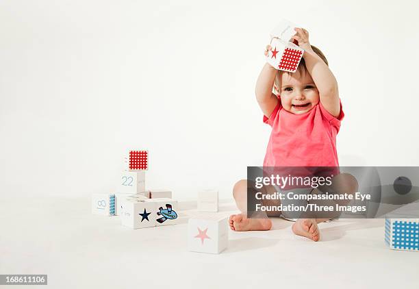 smiling baby playing with wooden blocks - baby blocks stock pictures, royalty-free photos & images