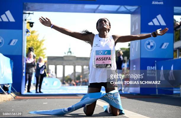 Ethiopia's Tigist Assefa celebrates after smashing the women's marathon world record by crossing the finish line to win the women's race of the...