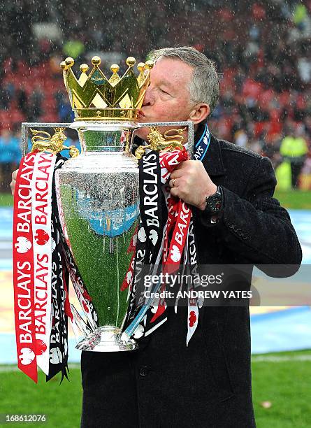 Manchester United's Scottish manager Alex Ferguson kisses the Premier League trophy at the end of the English Premier League football match between...