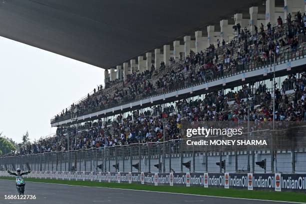 Leopard Racing's Spanish rider Jaume Masia gestures after winning the Moto3 race of the Indian Grand Prix at the Buddh International Circuit in...