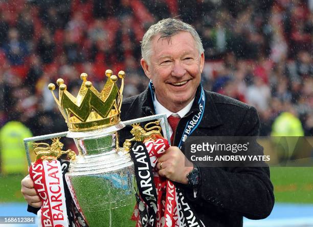 Manchester United's Scottish manager Alex Ferguson kisses the Premier League trophy at the end of the English Premier League football match between...