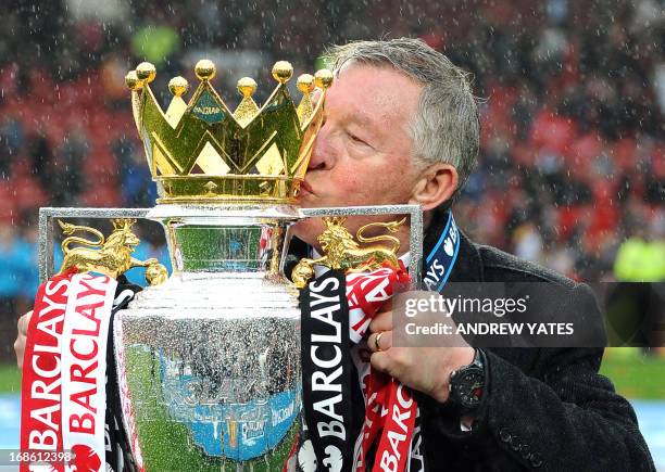 Manchester United's Scottish manager Alex Ferguson kisses the Premier League trophy at the end of the English Premier League football match between...