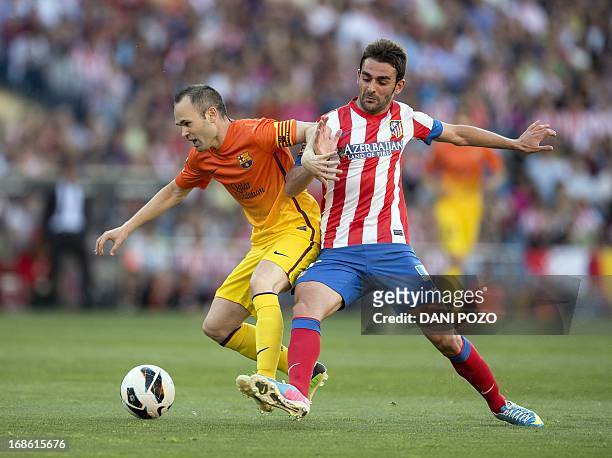 Barcelona's midfielder Andres Iniesta vies with Atletico Madrid's forward Adrian Lopez Alvarez during the Spanish league football match Atletico de...