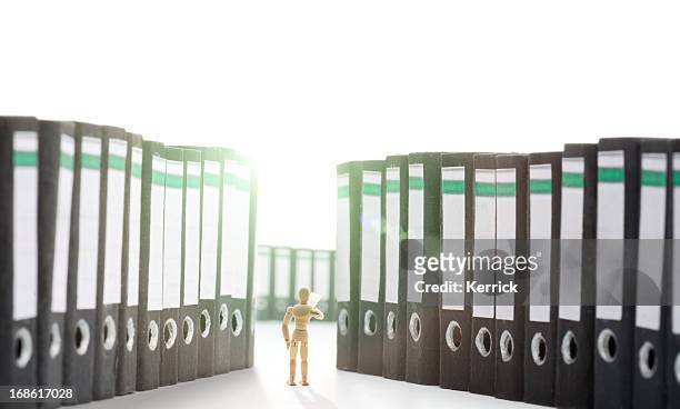 wooden mannequin in folders - ordner büro stock pictures, royalty-free photos & images