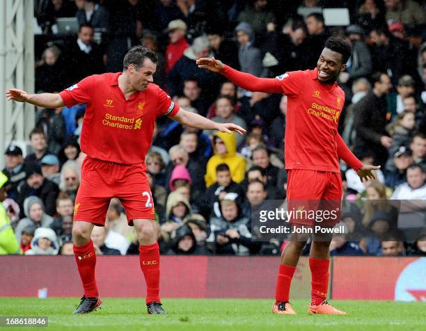 Daniel Sturridge of Liverpool celebrates after his hat-trick goal with Jamie Carragher during the Barclays Premier League Match between Fulham and...