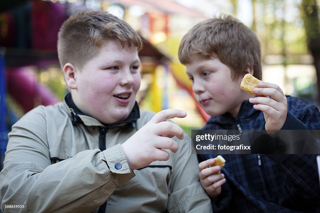 Alimentação Não-saudável: Dois rapazes com excesso de ingestão de chicken nuggets
