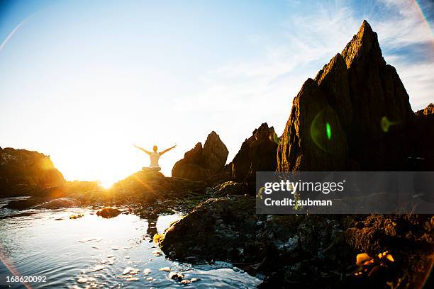 female meditating on the rocks - self reflection stock pictures, royalty-free photos & images