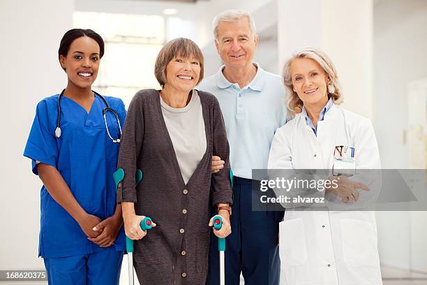 senior woman with crutches and hospital staff - hhp5 stock pictures, royalty-free photos & images