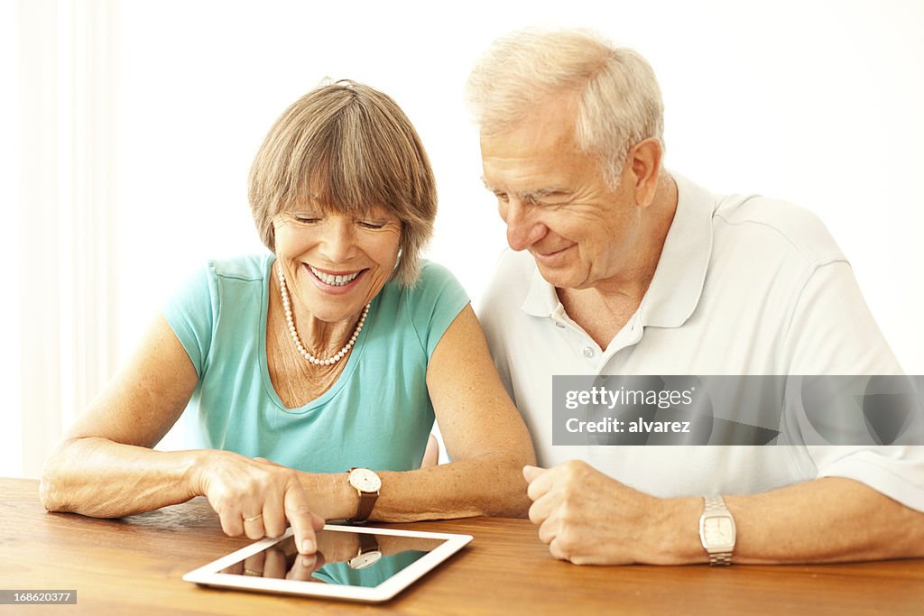 Pareja Senior jugando con una tableta digital
