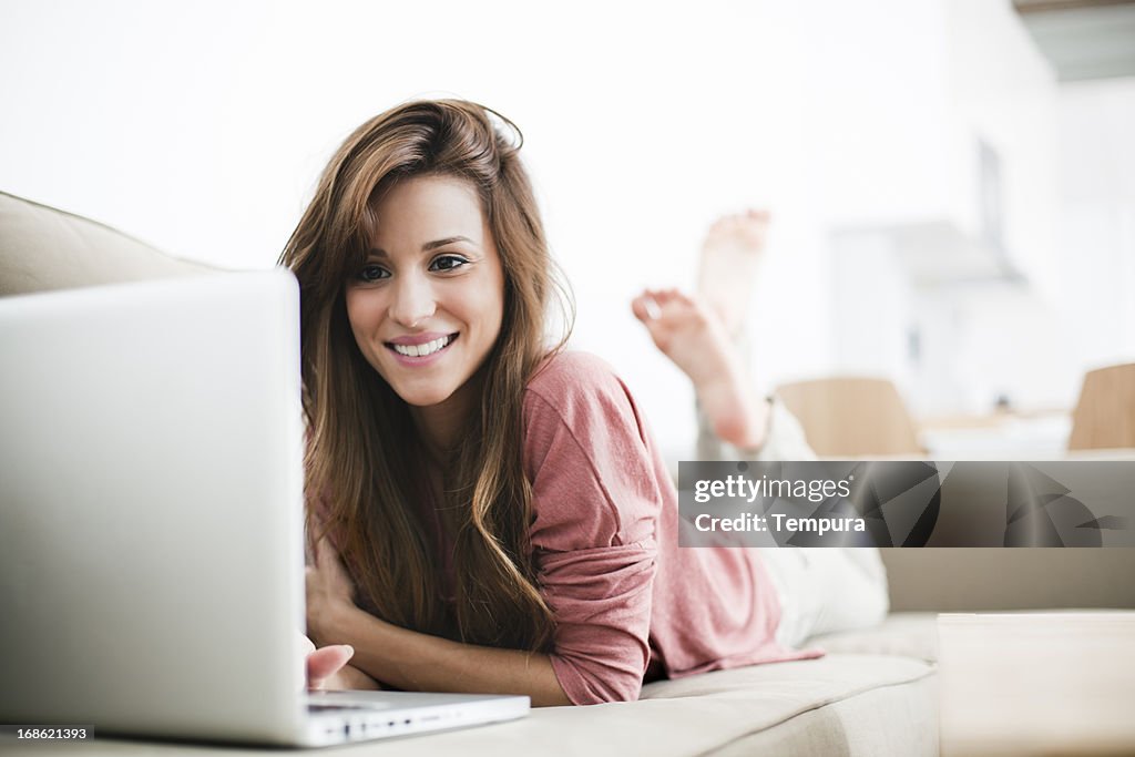 Giovane donna rilassante sul soggiorno in abbigliamento casual