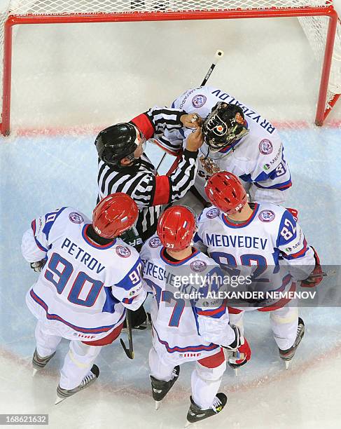 Referee helps Russia's goalkeeper Ilya Bryzgalov to adjust his helmet during the preliminary round match Slovakia vs Russia at the 2013 IIHF...