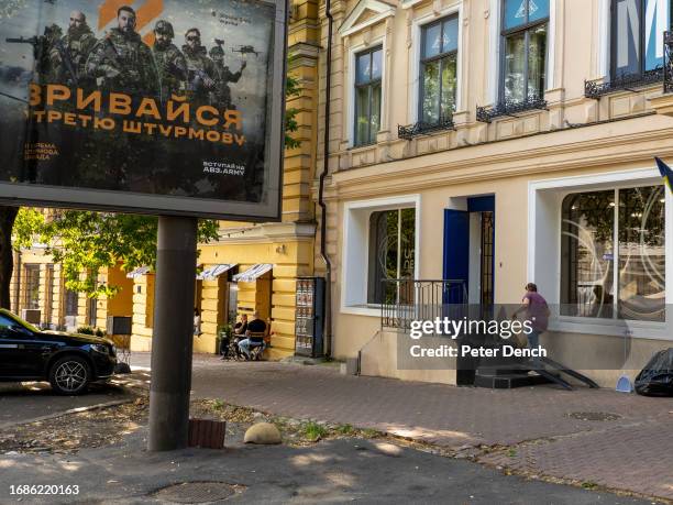 Woman finishes sweeping the street outside a business premises on August 26, 2023 in Odessa, Ukraine.