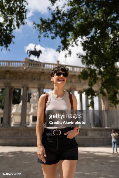 woman tourist strolling through a city park - madrid city stock pictures, royalty-free photos & images