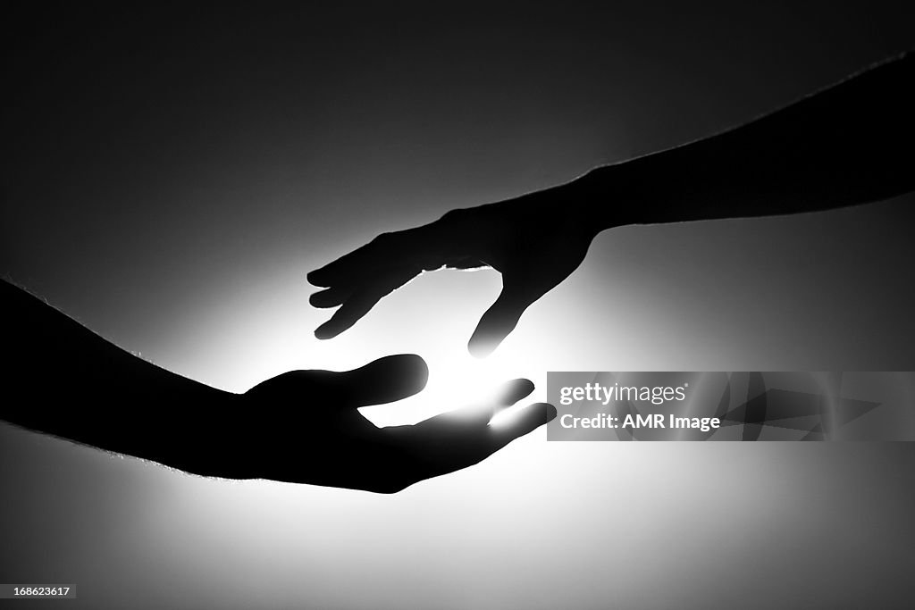 Black and white image of two hands reaching out
